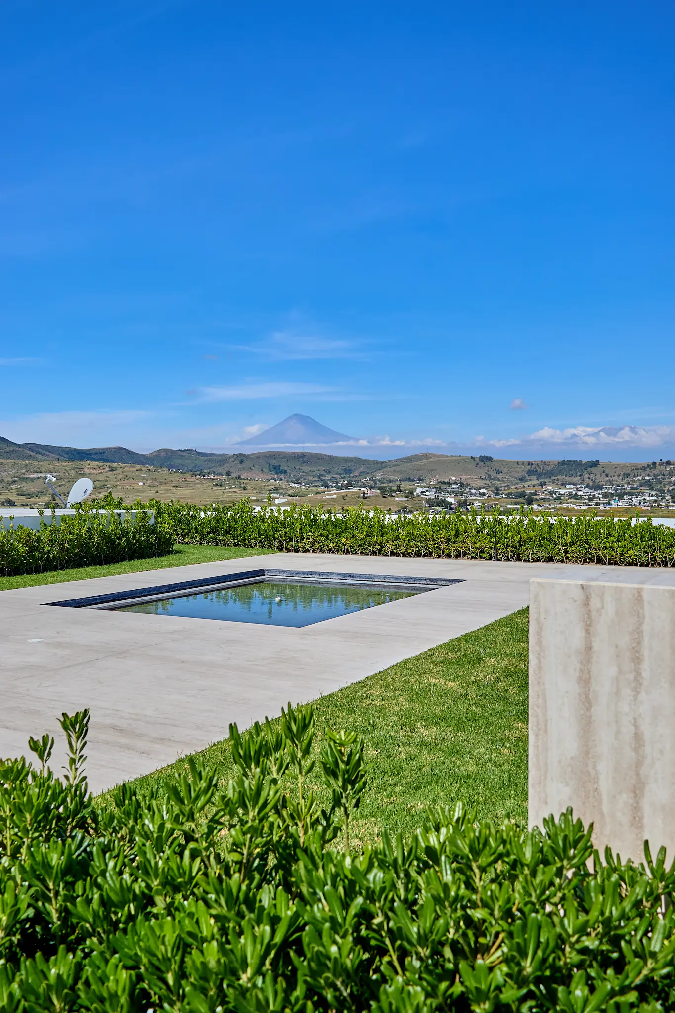 El Popocatépetl al fondo, visto desde el jardín y el espejo de agua del penthouse